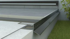 Profil okapowy zamontowany na krawędzi tarasu z płytkami ceramicznymi, widoczna perforowana listwa i warstwy montażowe.