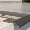 Detal krawędzi tarasu z płytkami ceramicznymi i profilem okapowym K100, pokazujący estetyczne wykończenie oraz ochronę krawędzi konstrukcji.