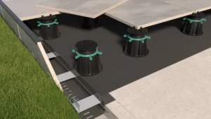 Widok tarasu wentylowanego z płytami ceramicznymi na regulowanych wspornikach oraz systemem odwodnienia liniowego zamontowanym wzdłuż krawędzi tarasu.