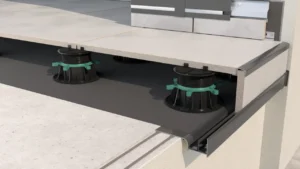 Widok krawędzi tarasu wentylowanego z płytami ceramicznymi na regulowanych wspornikach oraz aluminiowym profilu okapowym systemu W20.