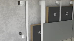 Widok montażu płyt elewacyjnych mocowanych do pionowych profili aluminiowych, z widoczną warstwą izolacji i podkonstrukcją ścienną.